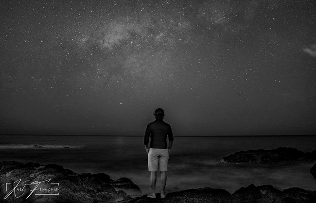 Long Exposure Photography of Man staring at the milky way in Albion Mauritius on rocky beach