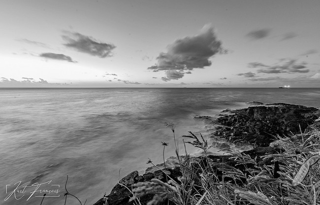 Coucher de soleil et photo longue exposition de la mer agitée prise depuis les falaises d'Albion à l'île Maurice avec le navire quittant Port Louis