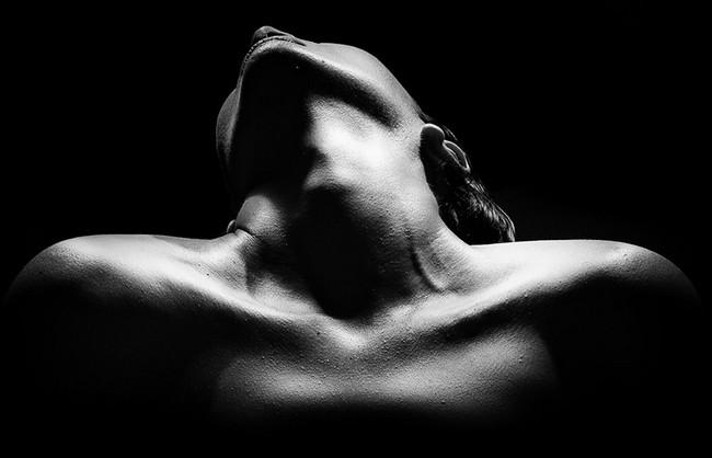 Photographie abstraite d'une femme nue et sensuelle sur fond noir