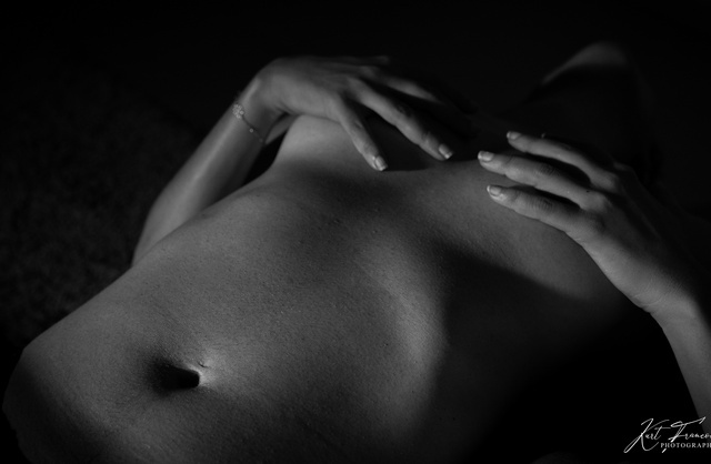 Photographie élégante en noir et blanc d'une jeune fille nue cachant ses seins