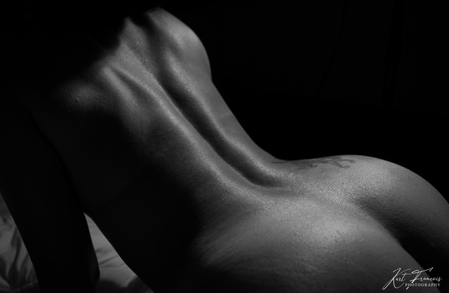 Photographie d'une femme nue montrant son dos et ses fesses